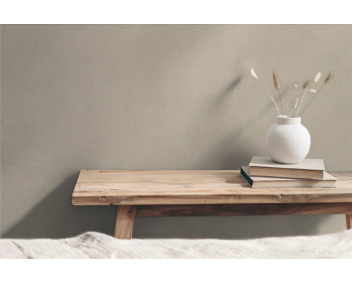 Holzbank mit Vase und Büchern vor einer Wand