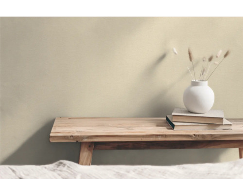 Holzbank mit Büchern und einer Vase mit Trockenblumen