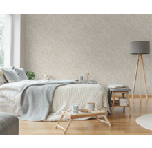 Helles Schlafzimmer mit gemusterter Tapete, Bett, Stehlampe und Holzfußboden.