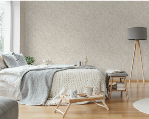 Helles Schlafzimmer mit gemusterter Tapete, Bett, Stehlampe und Holzfußboden.