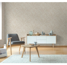 Wohnzimmer mit gemusterter Tapete, Sessel, Couchtisch und Sideboard