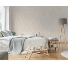 Schlafzimmer mit Bett, Beistelltisch, Stehlampe und Tapete mit Blattmuster