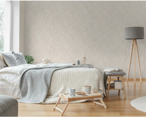 Schlafzimmer mit Bett, Beistelltisch, Stehlampe und Tapete mit Blattmuster