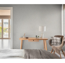 Schlafzimmer mit gemusterter Tapete, Schreibtisch, Stuhl und Bett