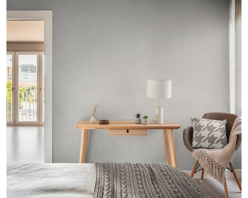 Schlafzimmer mit gemusterter Tapete, Schreibtisch, Stuhl und Bett