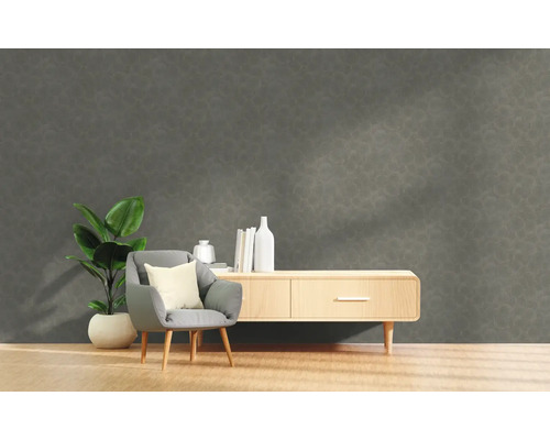 Wohnzimmer mit grauer Strukturwand, Sessel, Pflanze und Kommode