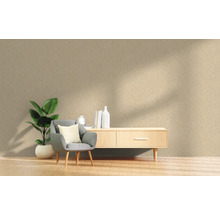 Wohnzimmer-Szene mit Sessel, Zimmerpflanze und Sideboard im skandinavischen Stil