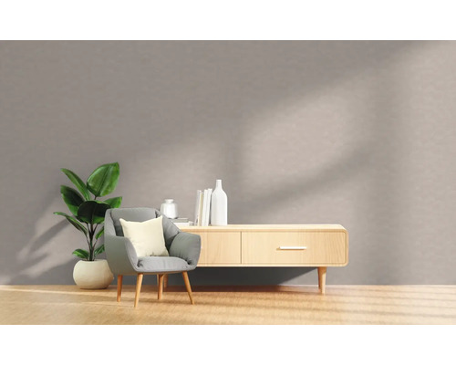 Wohnzimmer mit Sessel, Zimmerpflanze und Sideboard