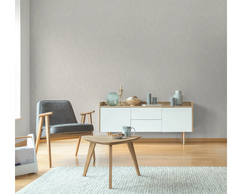 Wohnzimmer mit Sessel, Tisch und Sideboard