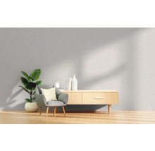 Wohnzimmer mit Sessel, Zimmerpflanze und Holzkommode