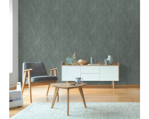 Wohnzimmer mit strukturierten Tapeten, Sessel, Sideboard und Tisch