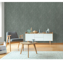 Wohnzimmer mit grauer Tapete, Sessel und Holzmöbeln