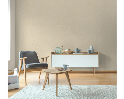 Wohnzimmer mit Sessel, Couchtisch und Sideboard vor einer gemusterten Tapete