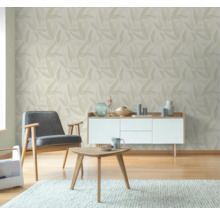 Wohnzimmer mit Blättertapete, Sessel, Tisch und Kommode