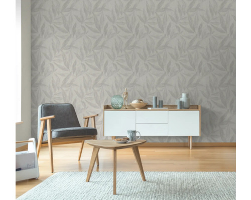 Wohnzimmer mit Blattmuster-Tapete, Sessel, Tisch und Kommode