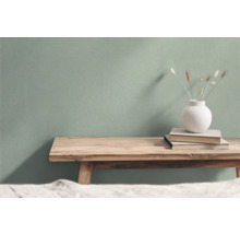 Wohnszene mit Holzbank, Büchern und Vase vor einer Wand