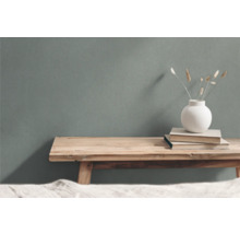 Dekoratives Arrangement mit Holzhocker, Büchern und Vase mit Ziergras