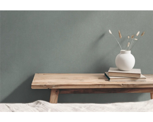 Dekoratives Arrangement mit Holzhocker, Büchern und Vase mit Ziergras
