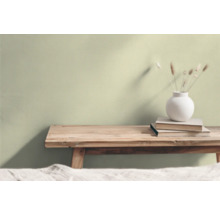 Wohnraum mit Holzhocker, Bücherstapel und Blumenvase