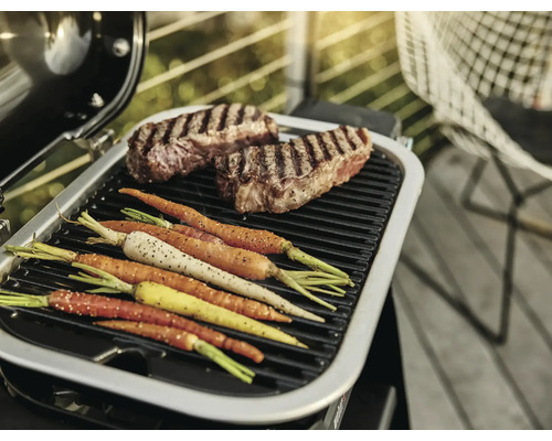 Grill mit Steaks und Karotten auf dem Grillrost