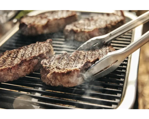 Steaks auf Grill mit Grillzange