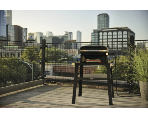 Weber Lumin Elektrogrill auf einem Balkon mit Stadtblick