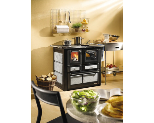 Holzherd mit Backofen und Kochutensilien in der Küche