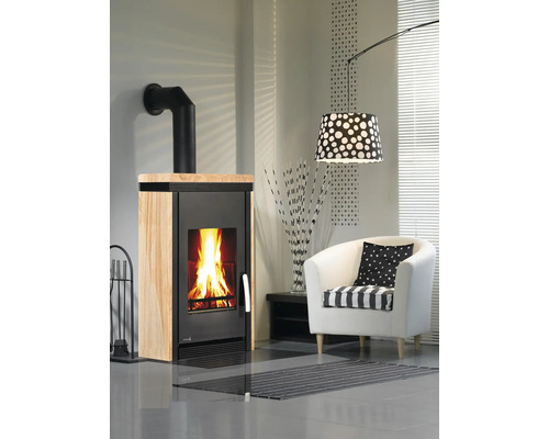 Kaminofen mit Brennholz und Kaminbesteck in einem Wohnzimmer.