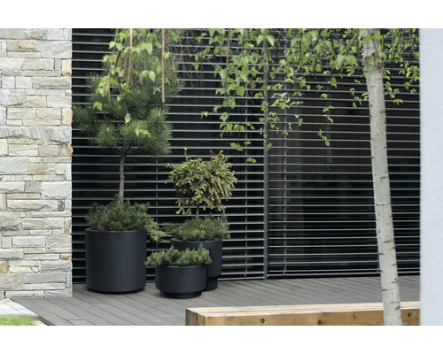 Außenbereich mit Pflanzen in Töpfen vor einer Wand mit horizontalen Lamellen