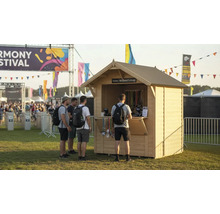 Festival Szene mit Ticketstand und wartenden Personen.
