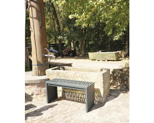 Szene im Freien mit einer Bank vor einem Steintrog