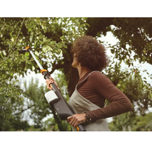 Frau benutzt eine Baumsäge für Gartenarbeiten.