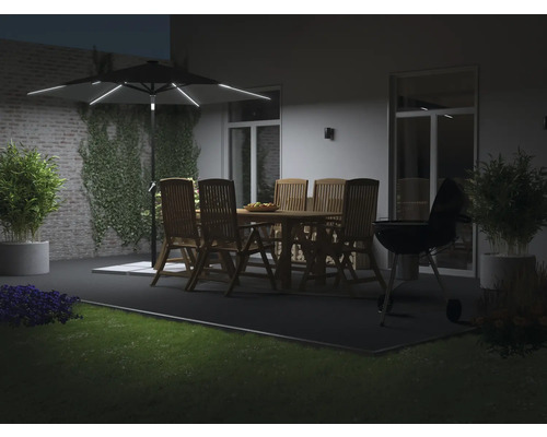 Beleuchteter Gartenschirm über einer Holzgarnitur und einem Grill auf einer Terrasse