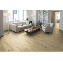 Wohnzimmer mit hellem Holzboden, Sofa, Sessel und Bücherregal