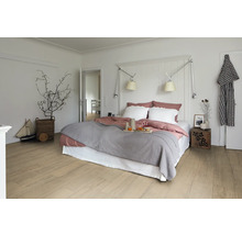 Heller Schlafzimmerraum mit Doppelbett, Holzboden und dekorativen Elementen