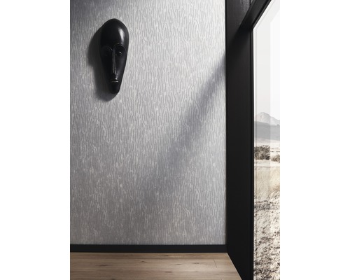 Raumansicht mit gemusterter Tapete und dekorativer Maske an der Wand