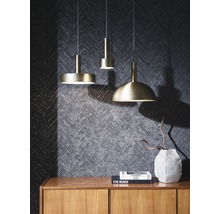 Drei Pendelleuchten unterschiedlichen Designs über einer Holzkommode