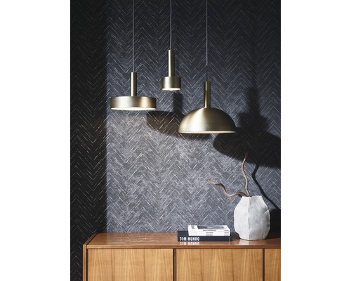 Drei Pendelleuchten unterschiedlichen Designs über einer Holzkommode