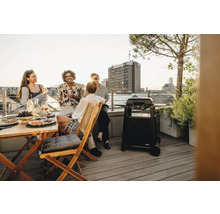 Gruppe von Personen grillt auf einer Dachterrasse mit einem Enders Gasgrill.