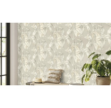 Wohnraum mit einer Tapete mit Pflanzenmuster, einem Kissen, einem Hut und einer Zimmerpflanze.