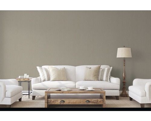 Wohnzimmer mit Sofa, Sessel, Couchtisch und Stehlampe vor einer strukturierten Tapete