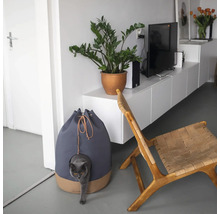 Katzenhaus neben einem Stuhl und einer Pflanze im Topf in einem hellen Wohnzimmer