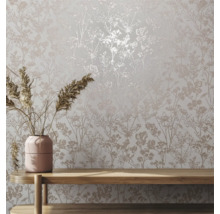 Nahaufnahme einer Wand mit floral gemusterter Tapete und einem Holztisch mit Blumenvase.