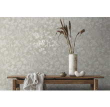 Szene mit Blumentapete, Holztisch, Vase und Dekorationsartikeln für ein helles, organisiertes Ambiente.