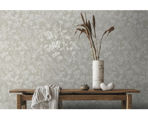 Szene mit Blumentapete, Holztisch, Vase und Dekorationsartikeln für ein helles, organisiertes Ambiente.