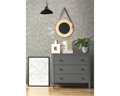 Dekoratives Interieur mit gemusterter Tapete, Kommode, Spiegel, Lampe und Zimmerpflanze