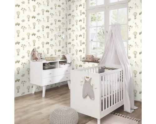 Babyzimmer mit gemusterter Tapete, Gitterbett und Kommode