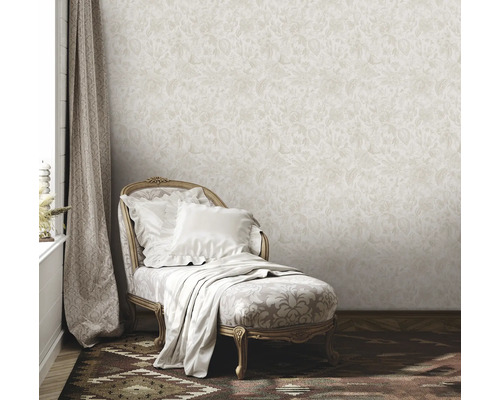 Szene mit beiger floral gemusterter Tapete, Liege mit Kissen und Decke sowie Vorhang