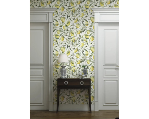 Raumansicht mit Tapete mit Zitronen- und Olivenmuster, Kommode, Lampe und weißen Türen.