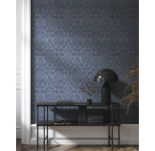 Raumansicht mit dunkel gemusterter Tapete, Konsole, Lampe und Dekoration